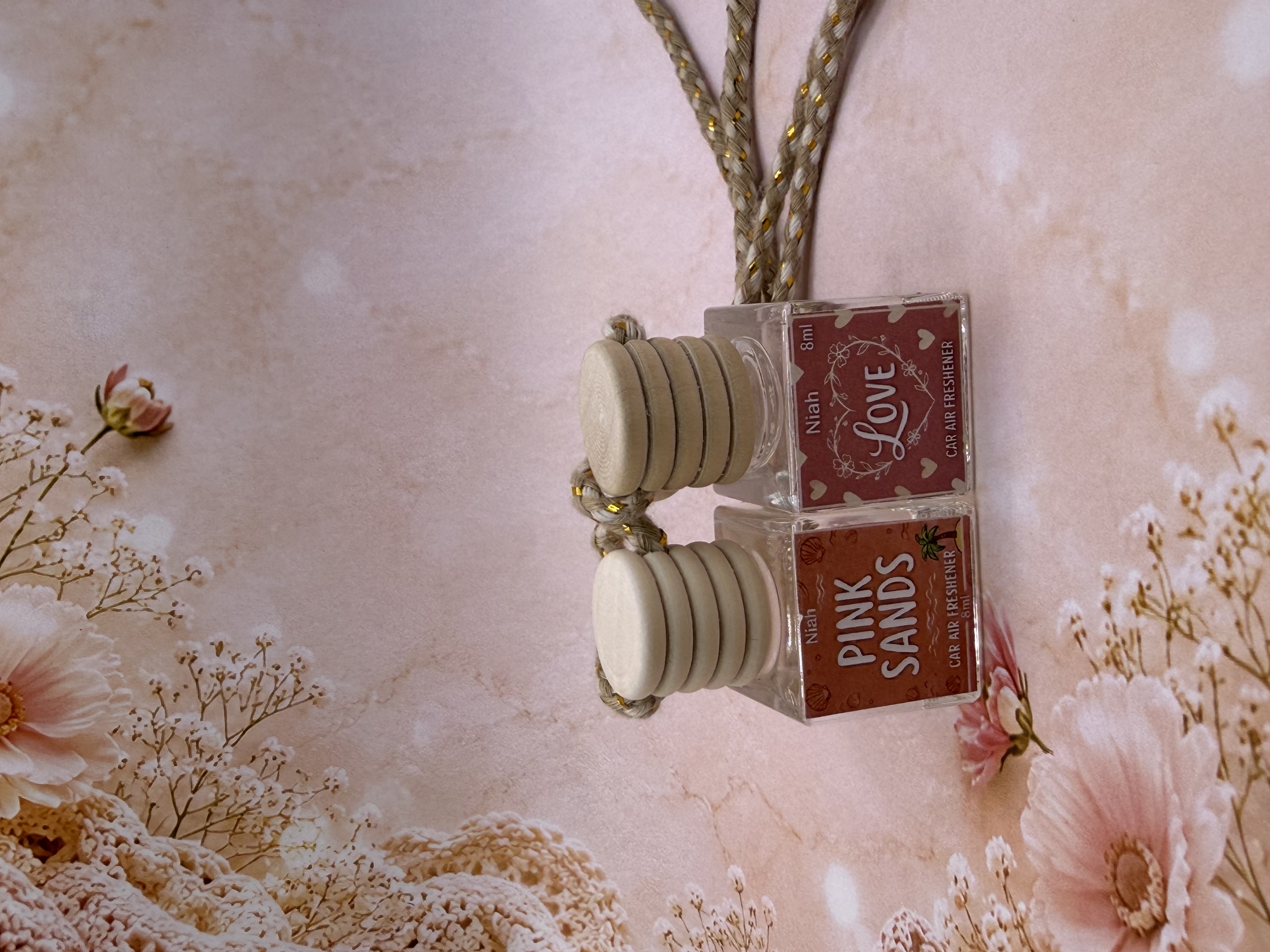 Niah Naturals handmade car air fresheners — Pink Sands and Love on soft floral background